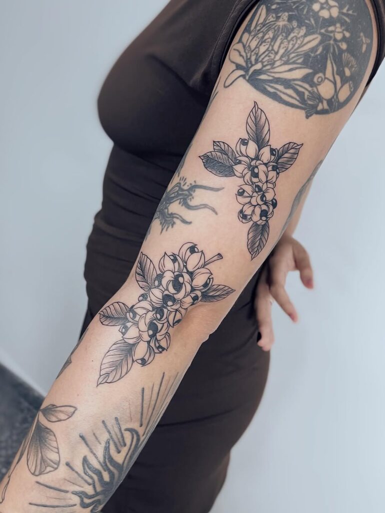 Braço com múltiplas tatuagens botânicas autorais convivendo em composição harmônica, novos trabalhos integrados a peças anteriores, executadas no estúdio Flag Haus, São Paulo