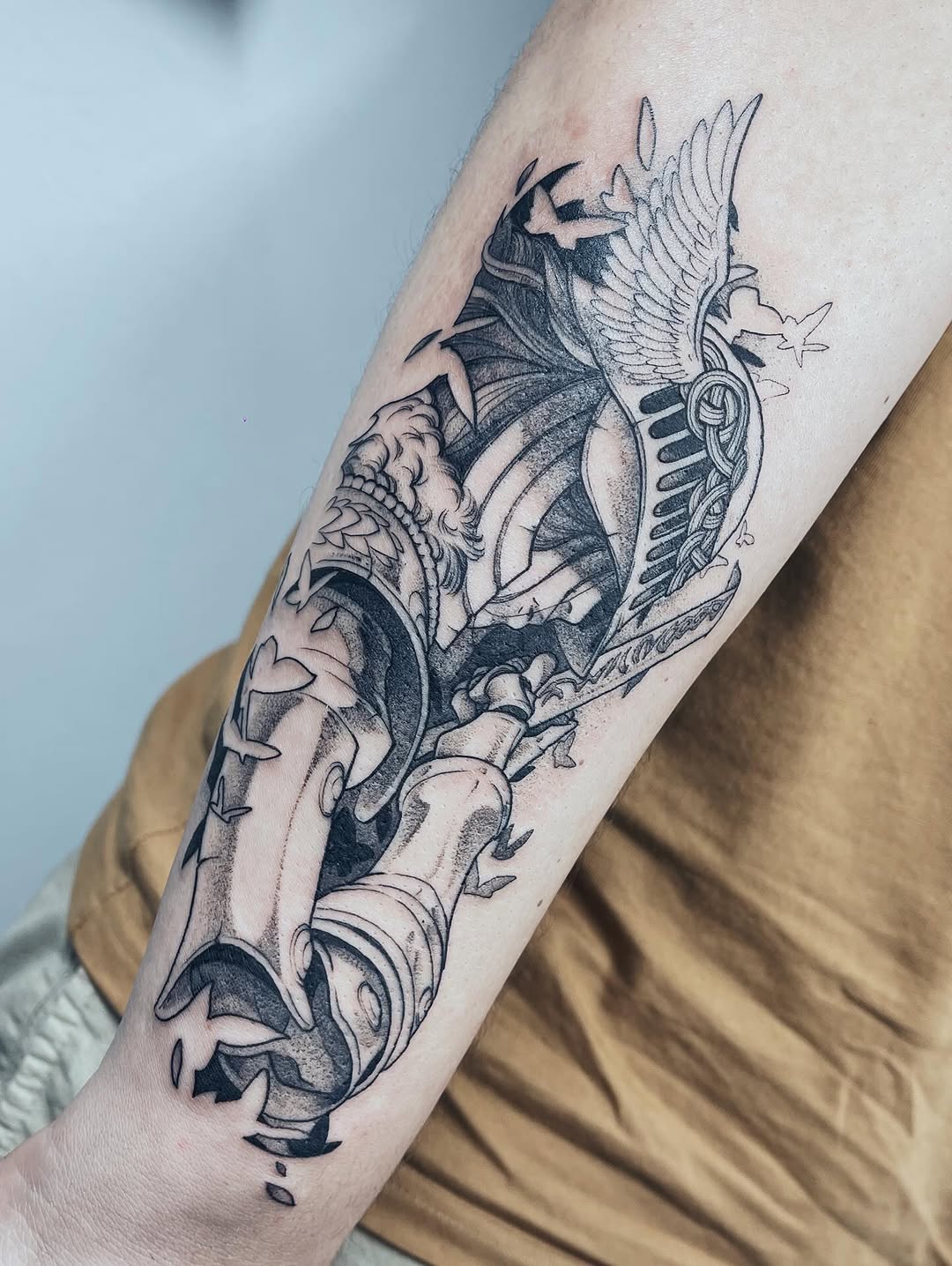 Tatuagem autoral de guerreiro com asa no elmo segurando espada, peça complexa de grande porte no antebraço, executada em múltiplas sessões na Flag Haus, Vila Mariana, São Paulo