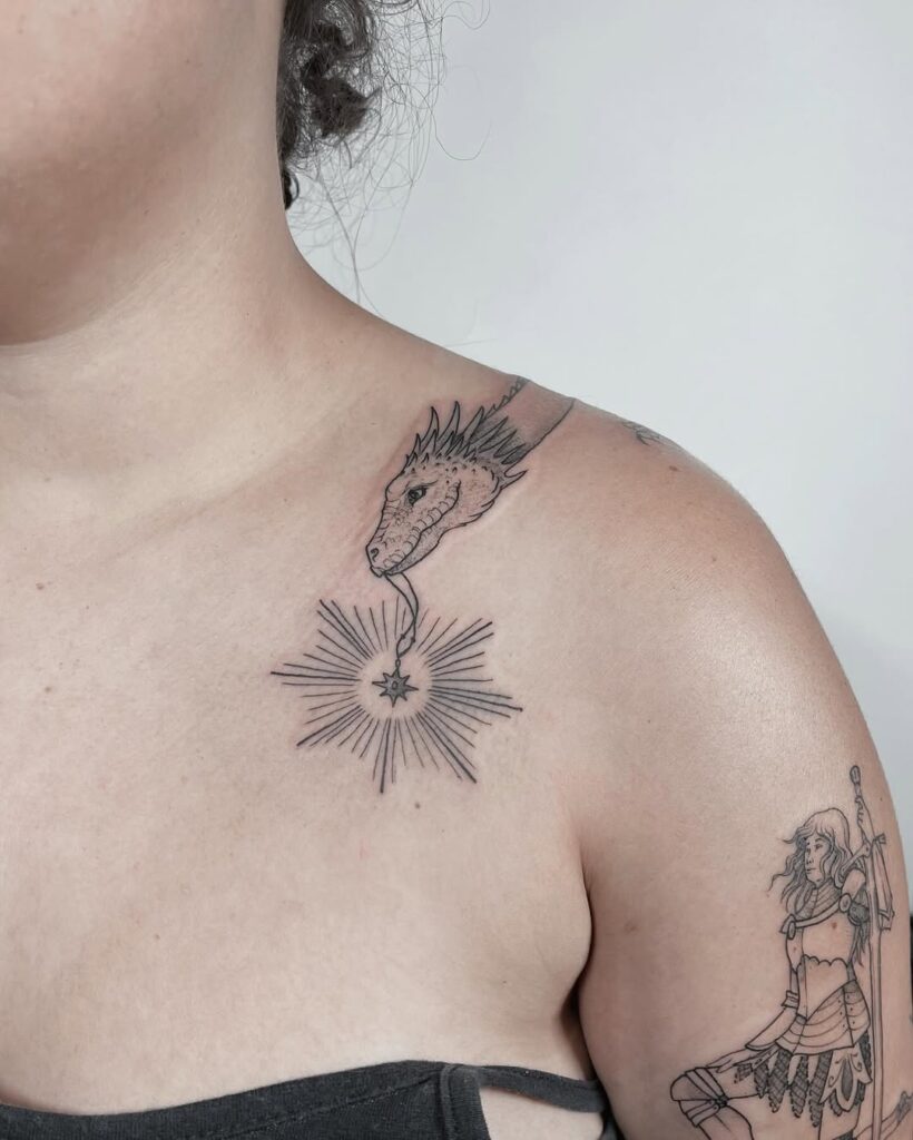 Tatuagem de cabeça de dragão em fine line com estrela e raios na clavícula, feita por Julio Bandeiras na Flag Haus